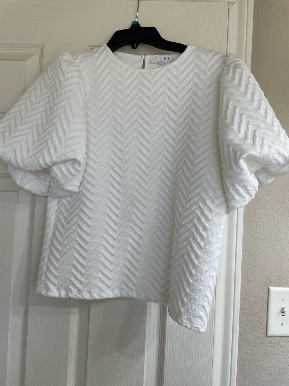 HTML Embossed, white knit top, bubble sleeve.
